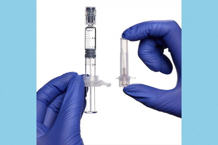blue gloves holding syringe and needle