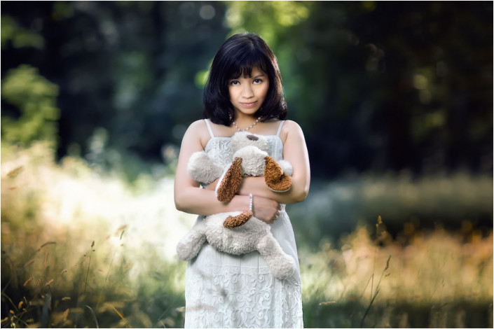 pretty girl with cuddly toy in field
