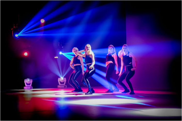 dancers on stage with colourful lighting
